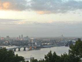 imagen de una ciudad de fondo con un puente que atraviesa un rio